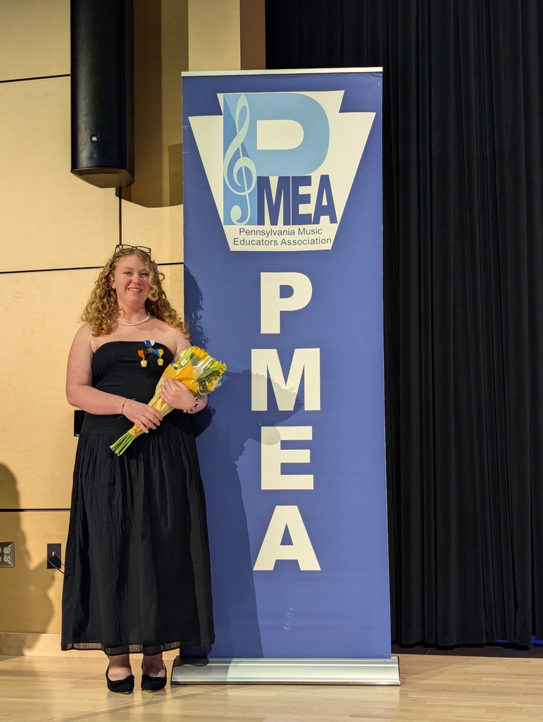 Student standing next to a PMEA banner