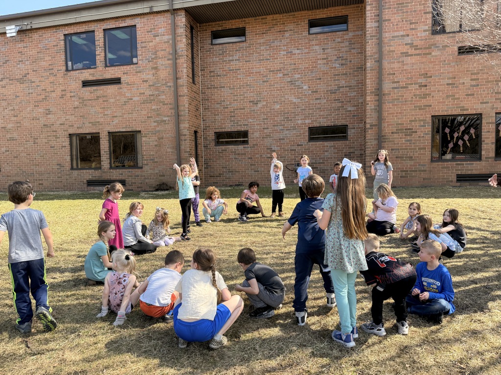 Students playing in the grass behind the school