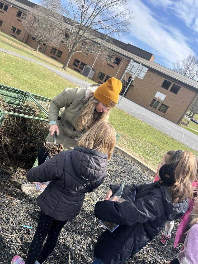 students line up to fill compost bins 
