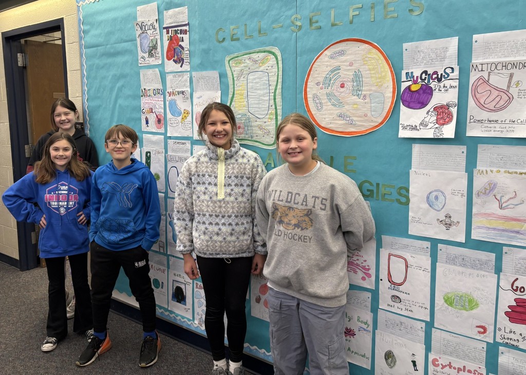 students standing in front of a bulletin board
