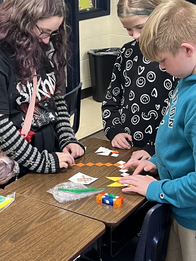 Students building quilt patterns in class.