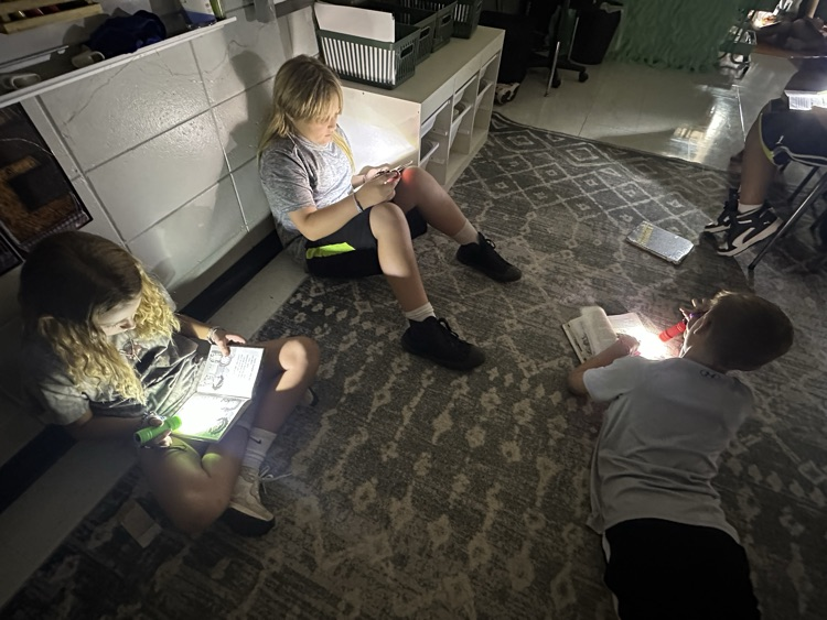kids reading by flashlight in fourth grade