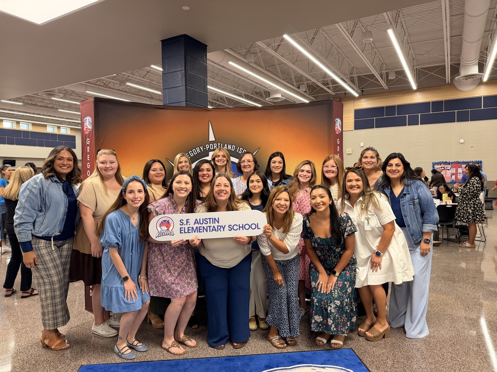 A group photo of people with a sign that says "S.F. Austin ELEMENTARY SCHOOL.