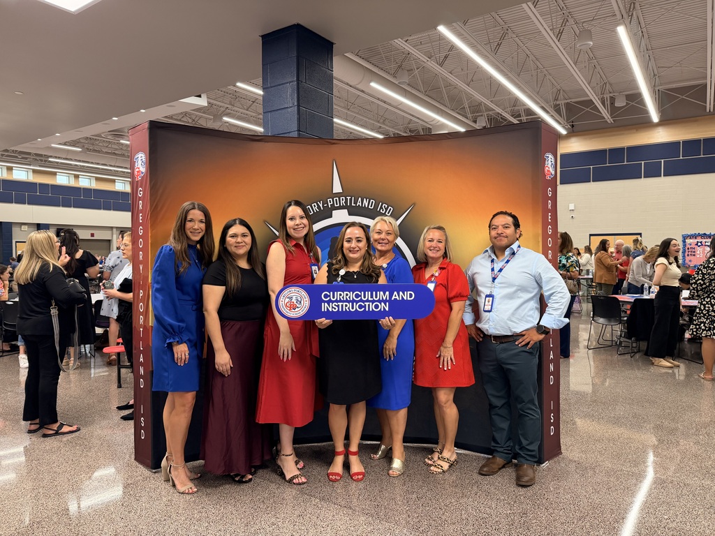 Group of people standing in front of a backdrop holding a sign that says "Curriculum and instruction."