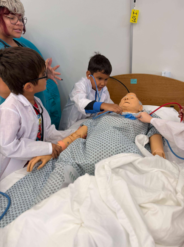 Medical staff attending to a patient in a hospital bed.