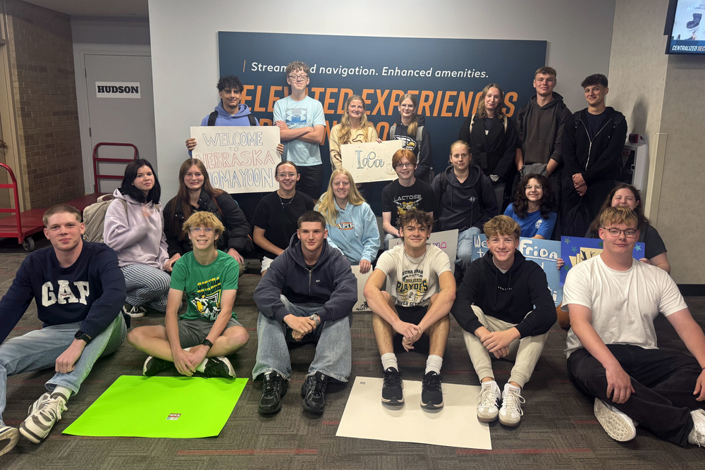 a photo of german exchange students at the airport with gretna students holding welcome signs.