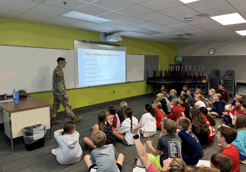 Photo of SSG Ethan Dannelly speaking to a 5th grade class about major military conflicts.