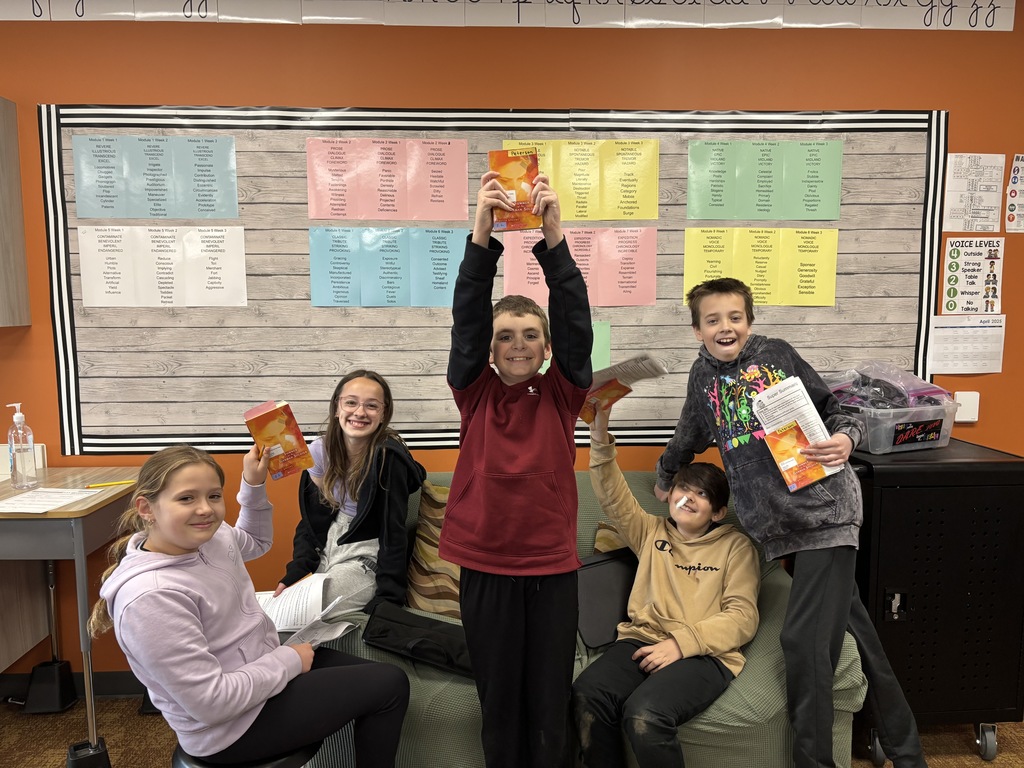 students sit together and share a novel in a group literature circle