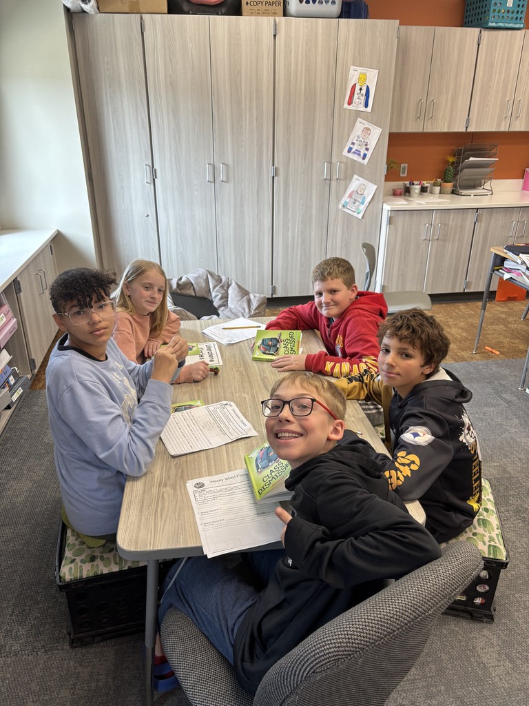 students sit together and share a novel in a group literature circle