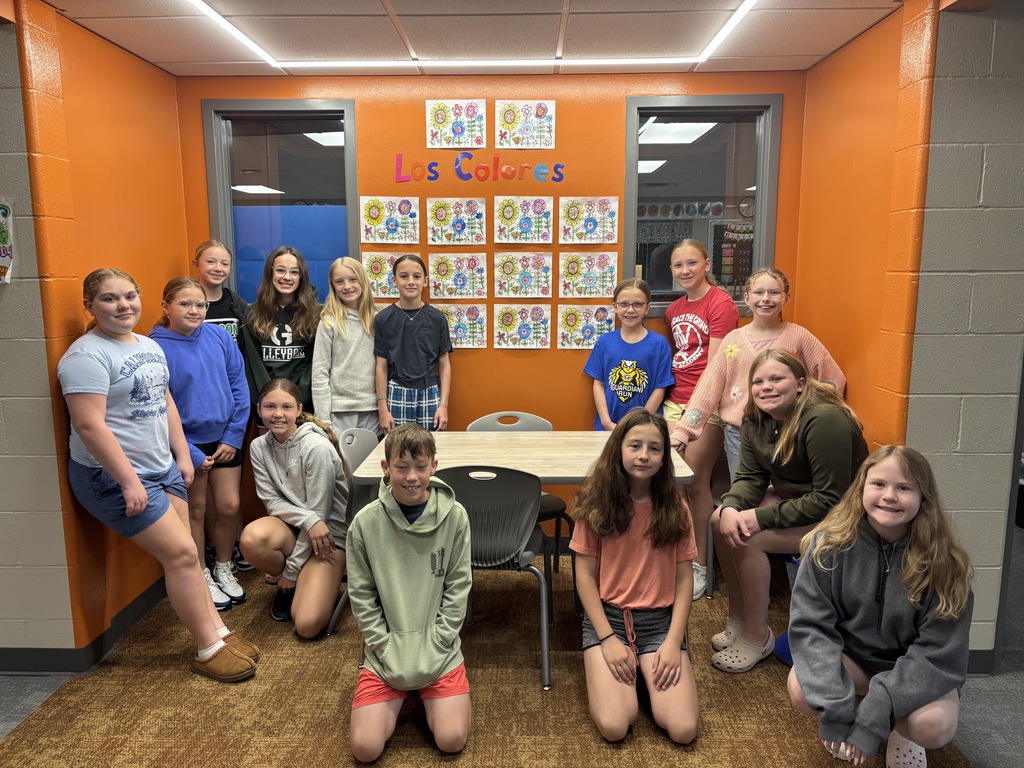 students smiling at the camera around their spanish themed work.