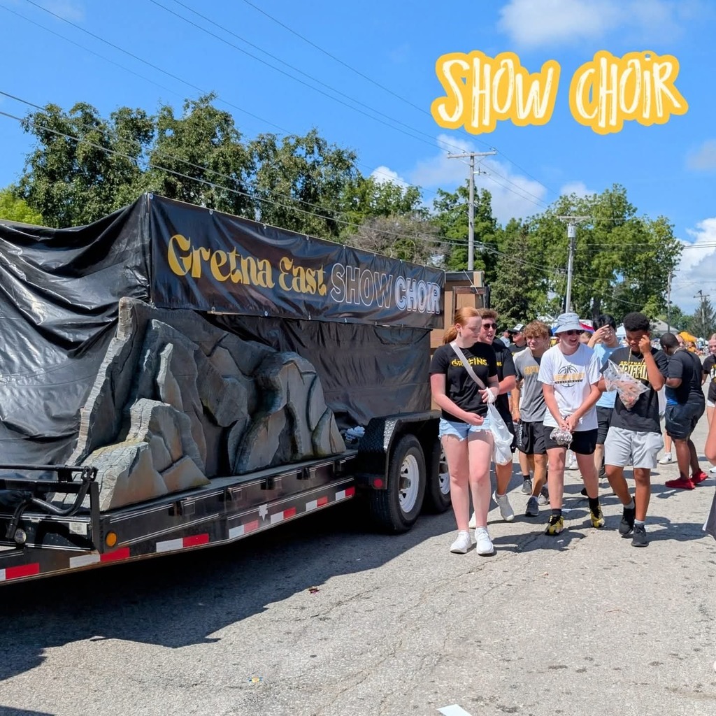 Gretna East show choir in Gretna Days parade walking beside float of a rock