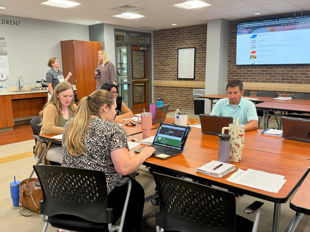 GPS staff members at table working on laptops
