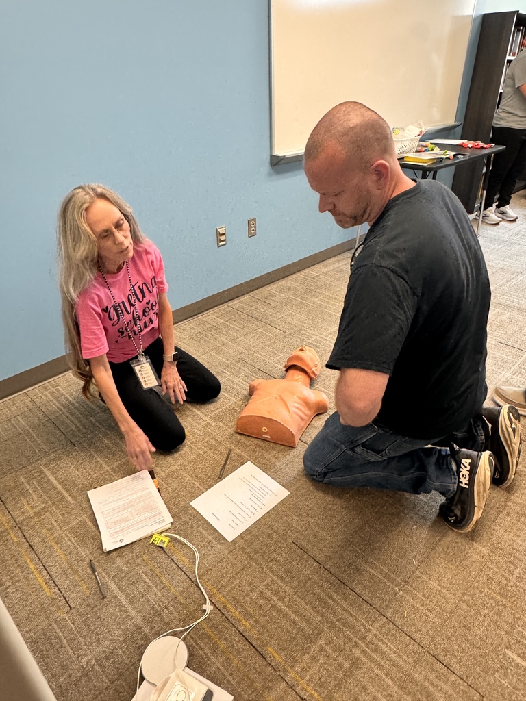 nurse guiding gretna public school coach on AED and CPR