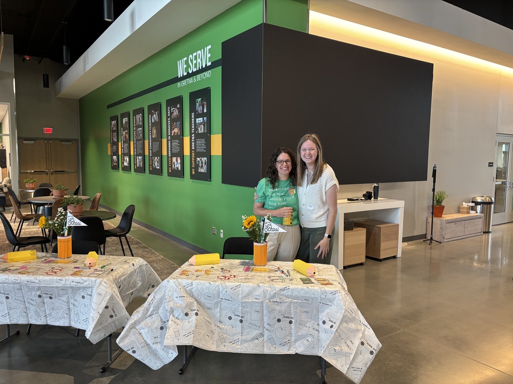 Two people standing together behind a table at Journey Church to host new staff members