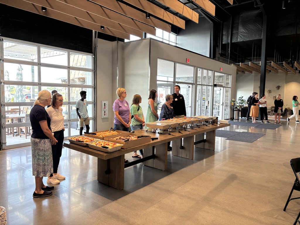 Journey Church members standing at the breakfast buffet to serve the new staff members from Gretna Public Schools