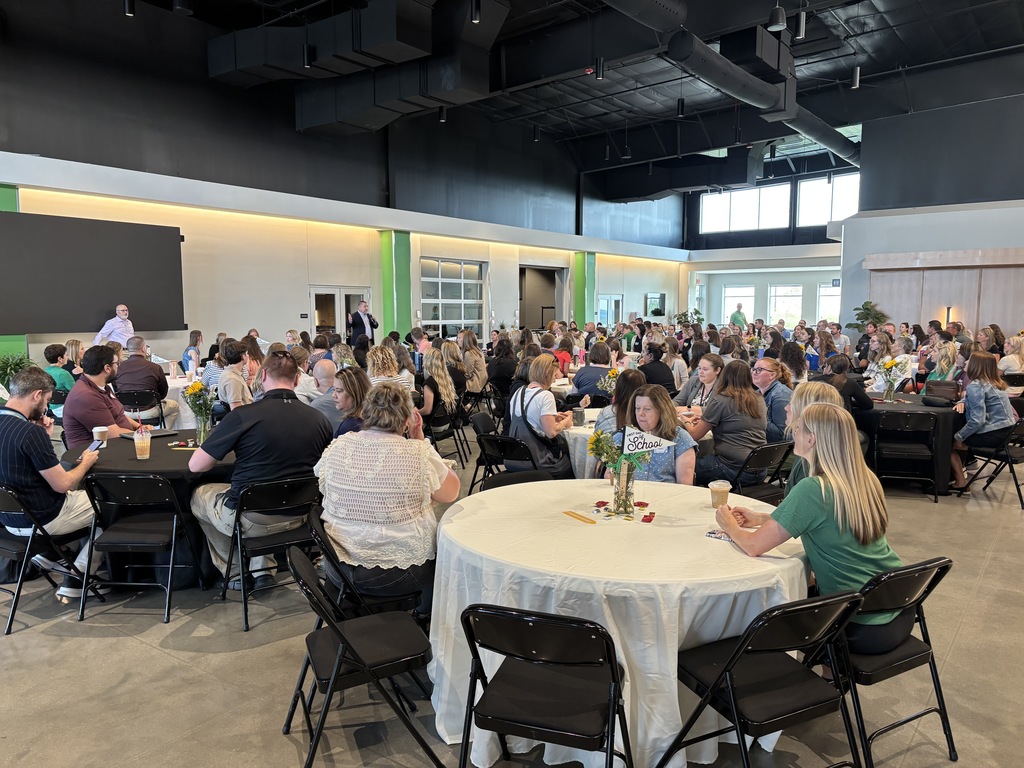 A large group of GPS new staff members sitting at round tables in a gathering area at Journey Church