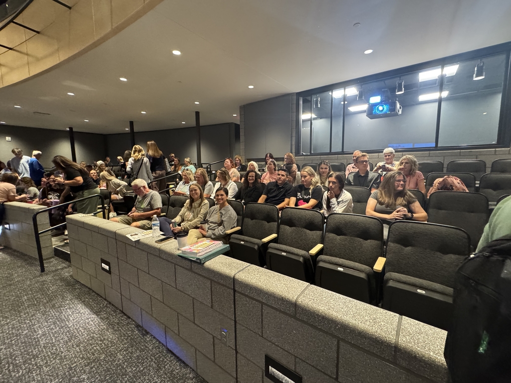 staff members seated in the auditorium waiting for speech to start