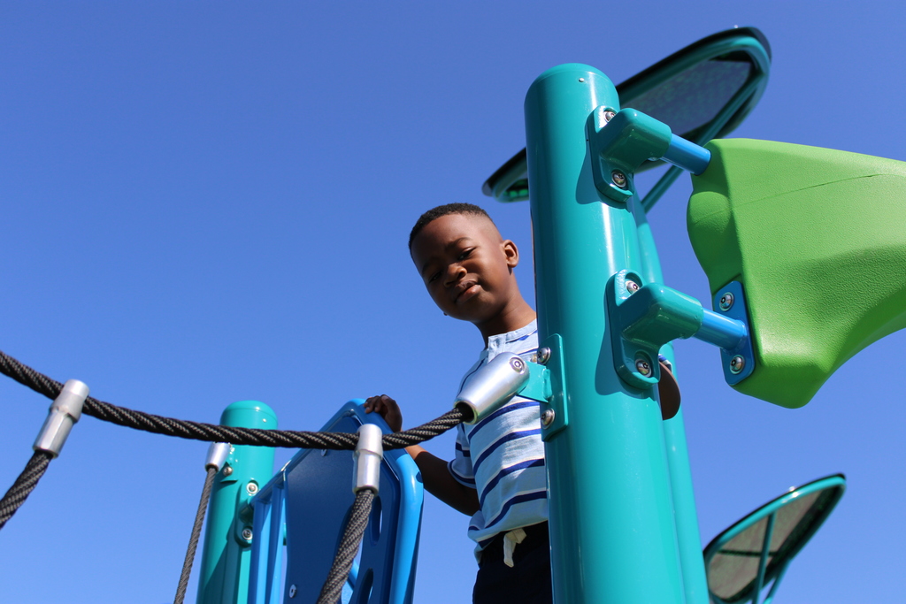 A young student has a moment of confidence as he navigates the new playground.