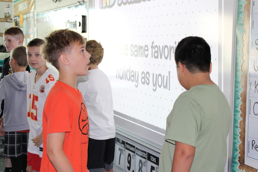 Students gather by the board, excitedly meeting the classmates with the same favorite holiday.