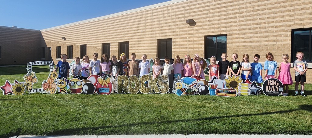 students smiling for a picture outside for the first day of school