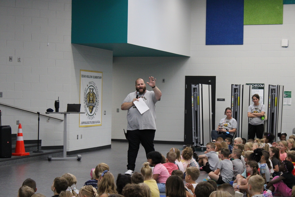 Mr. Runyon welcomes the crowd of students while holding a microphone, ready to kick off the first school assembly. 
