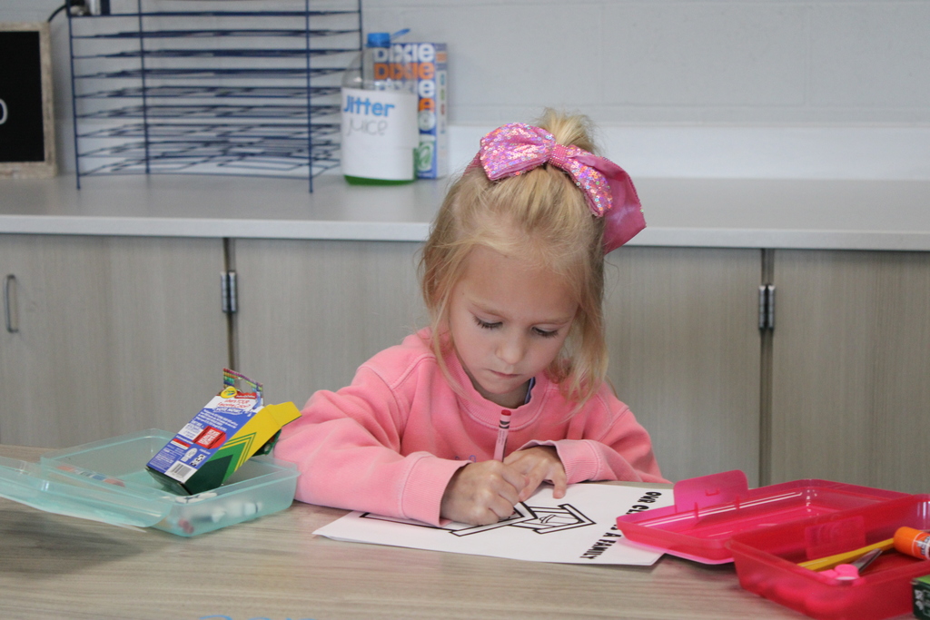 A young student engages in a coloring page!