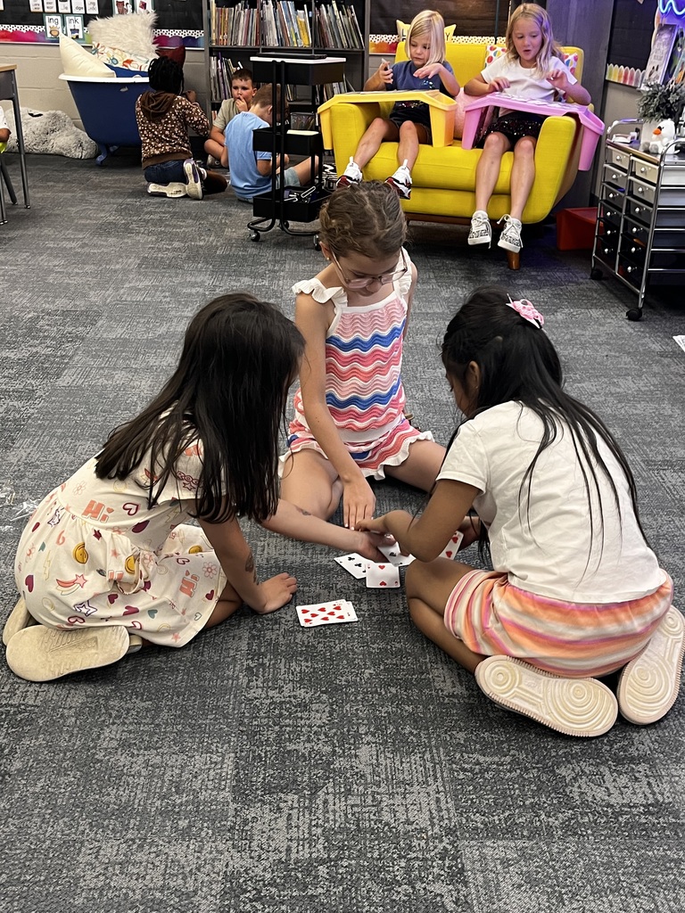 students play cards on the rug