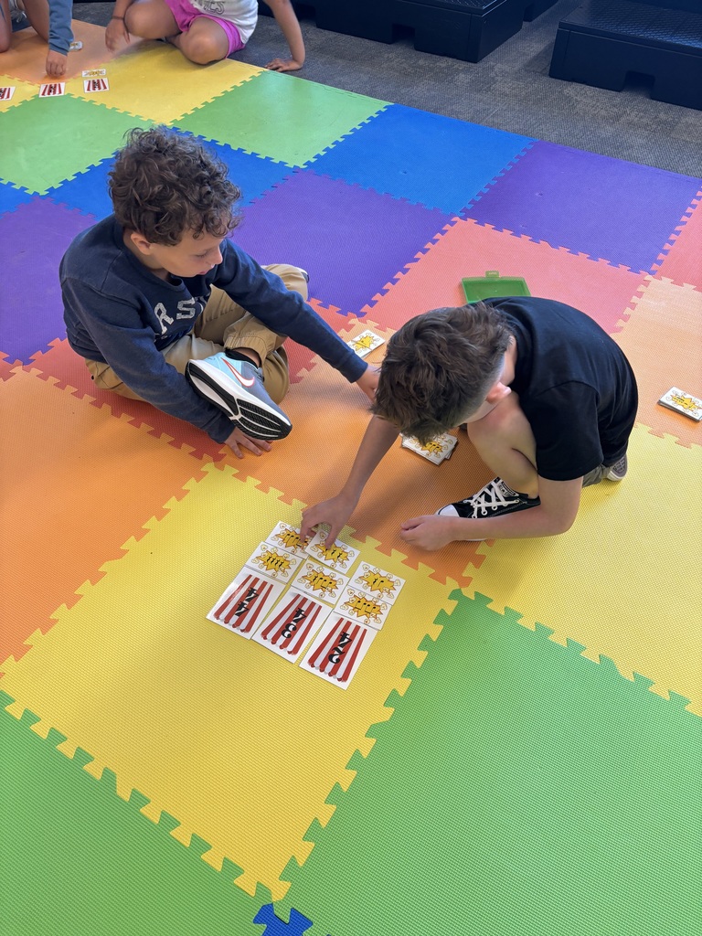 Students playing a card game on the floor