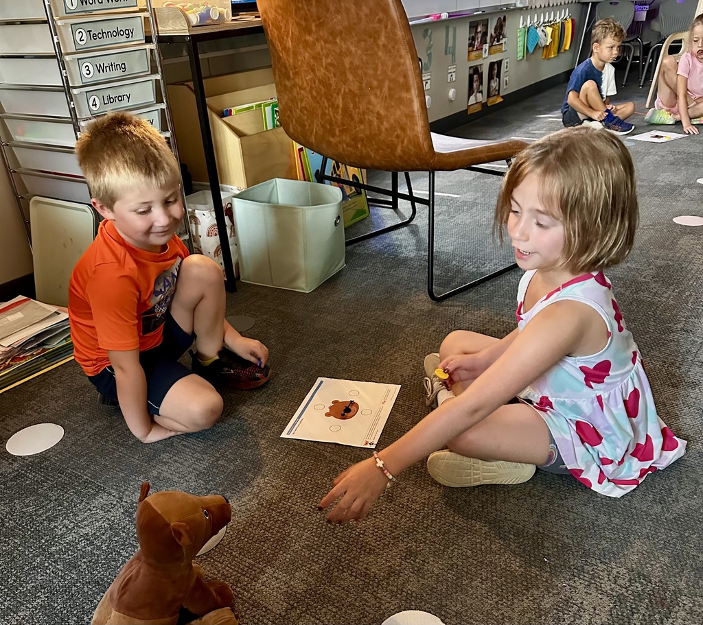 students learning with a game on the carpet in a classroom