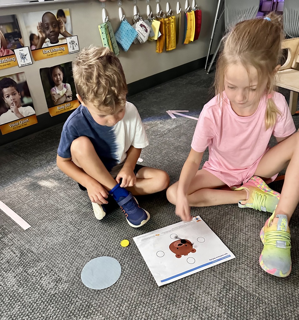 students learning with a game on the carpet in a classroom