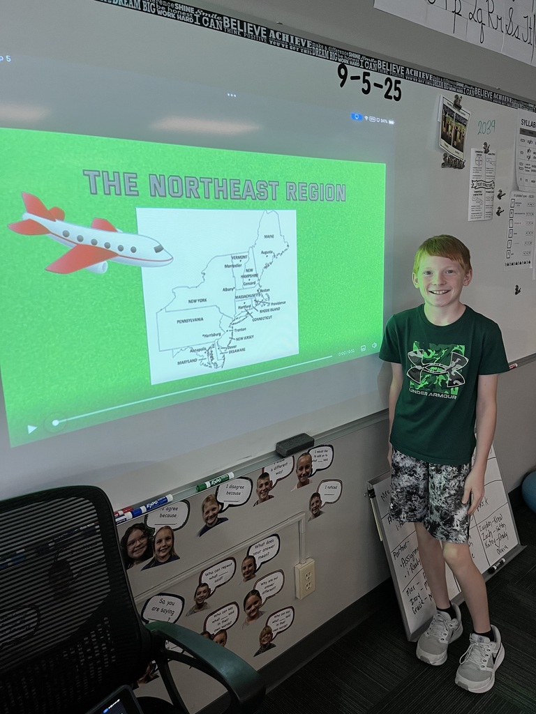 Boy standing in front of a whiteboard with a map of the Northeast region.