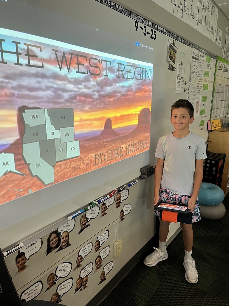 Boy standing in front of a whiteboard with a presentation of the west region.