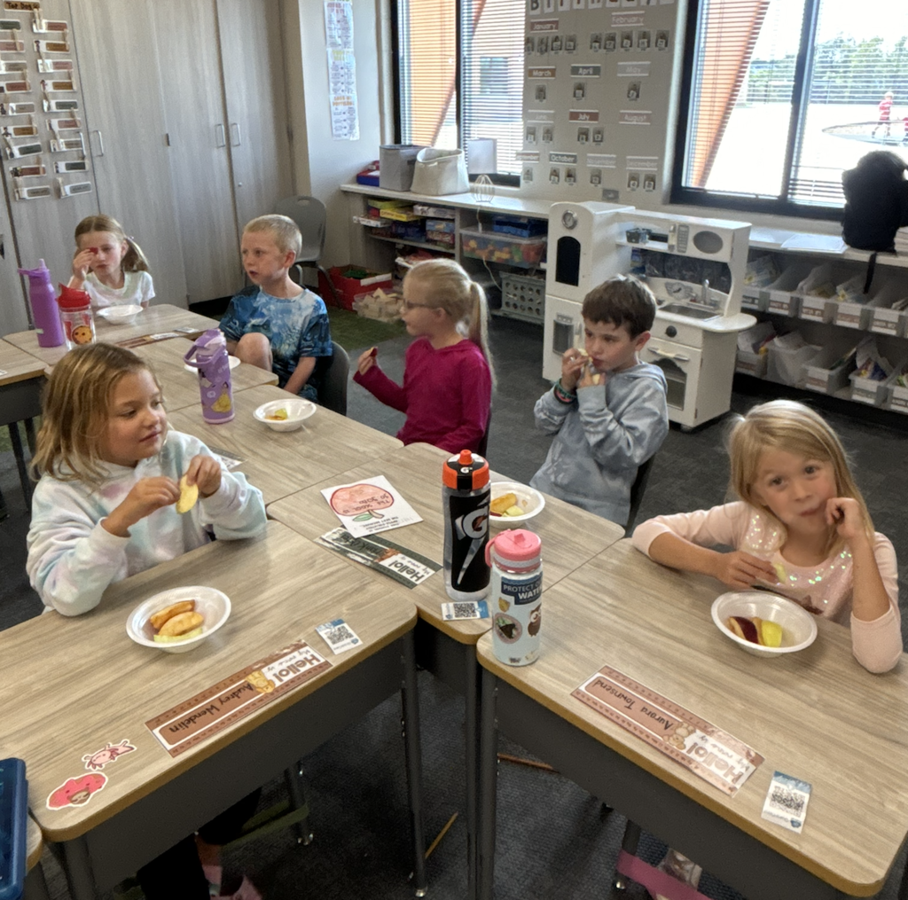 students tasting apples in their classroom