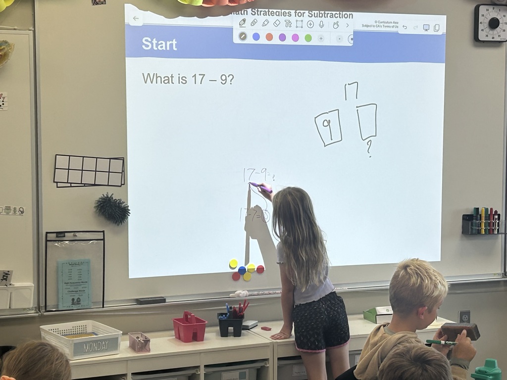 a student at the board showing math skills in a classroom