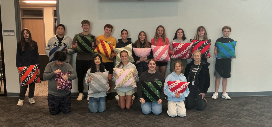 Students in Ms. Weis's 8th grade sewing class display their pillows. 