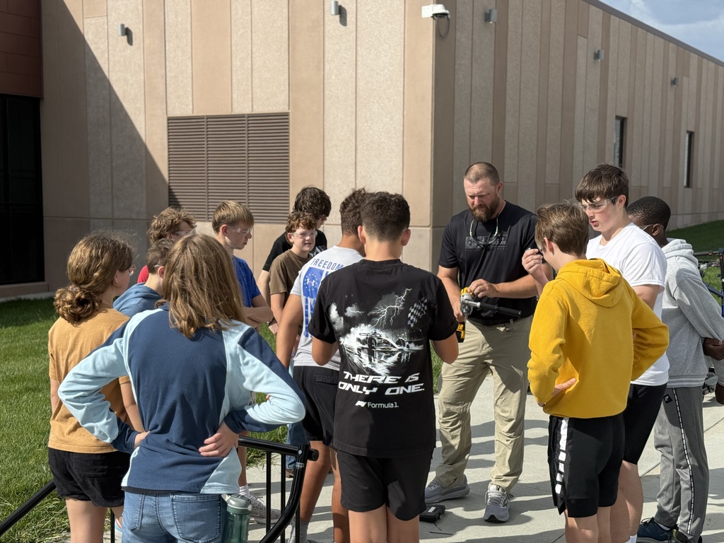 Mr. Jones and his 8th grade students attach the bike rack.