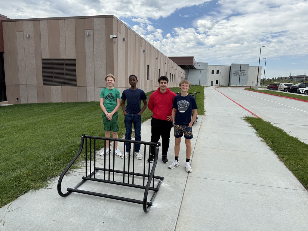Four 8th grade students stand by the newly installed bike rack. 