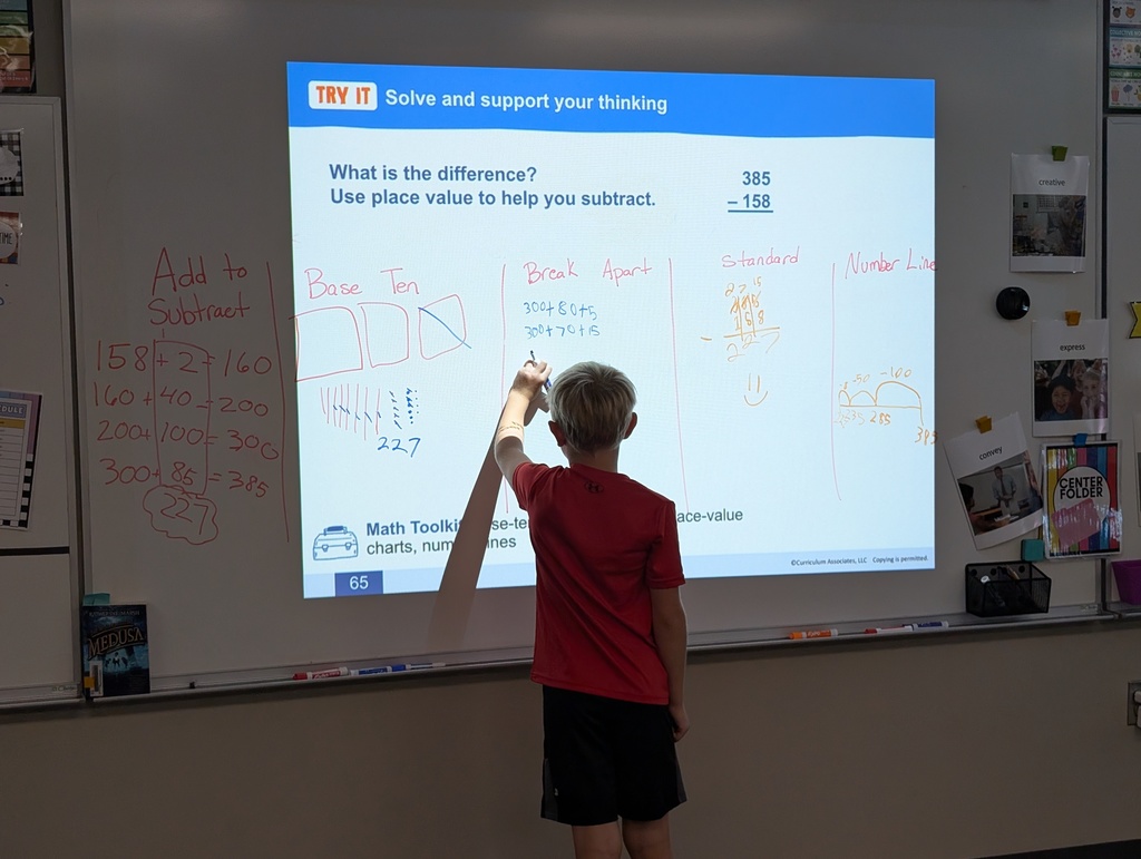 student at the board solving math