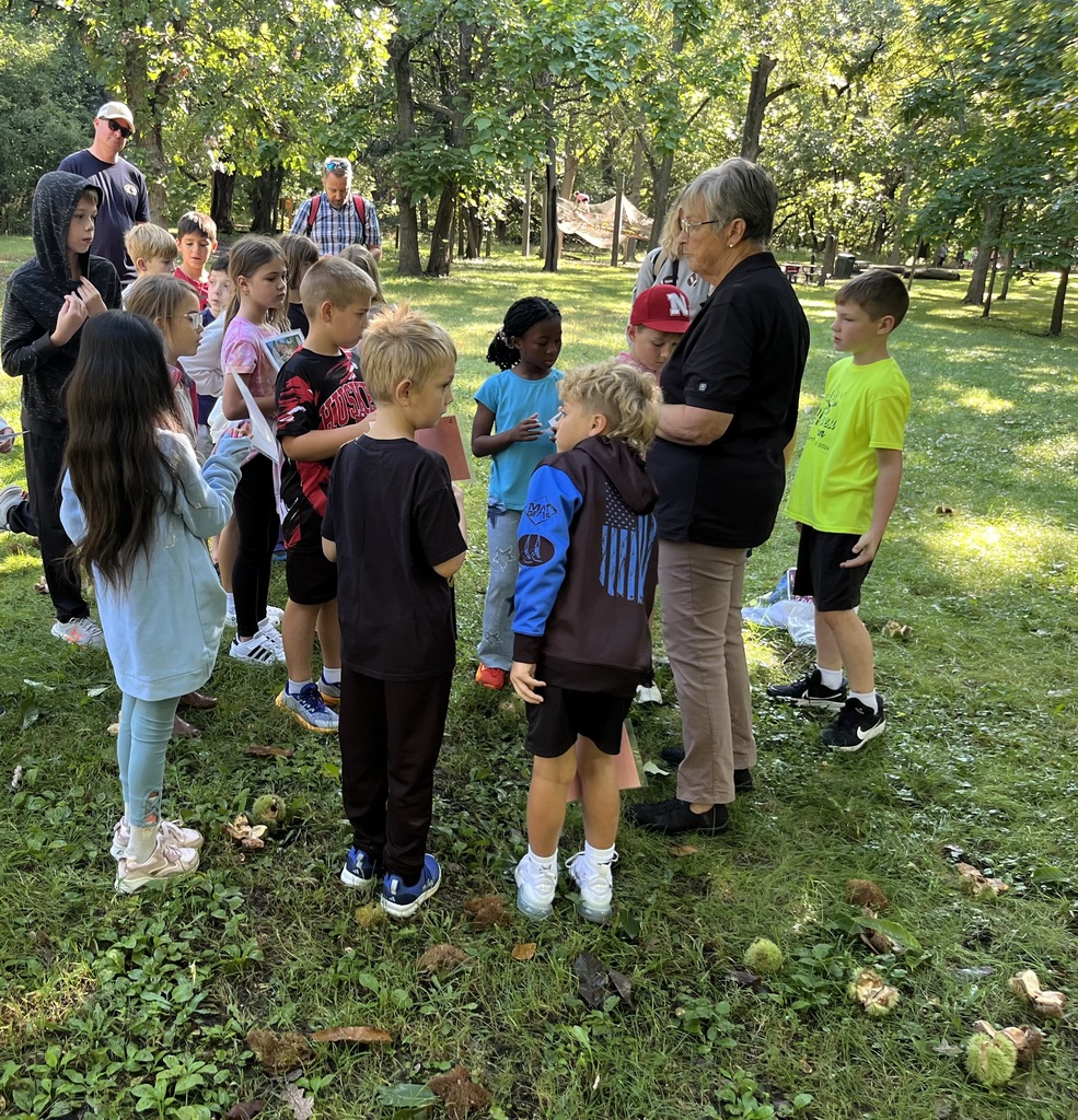 3rd graders on a field trip outside learning about trees.
