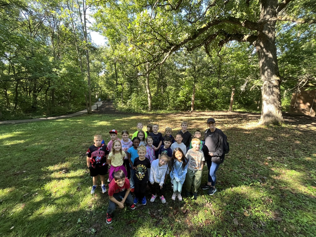 3rd graders on a field trip outside learning about trees.