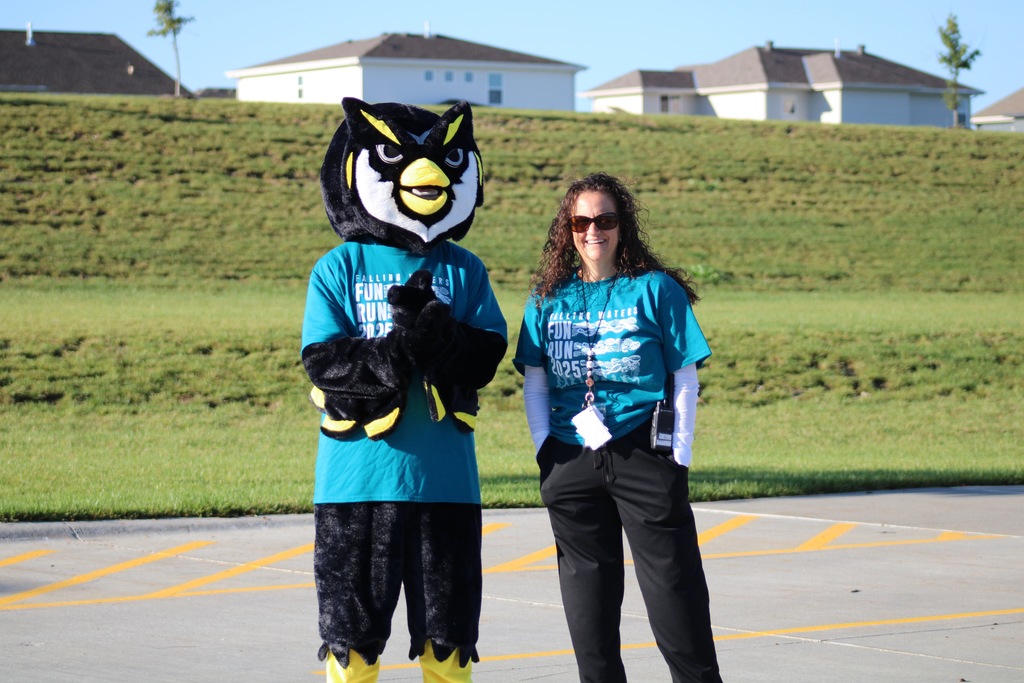 A Guardian mascot standing with our principal Mrs. Gabriel