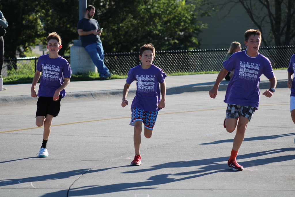 Two boys running in purple shirts