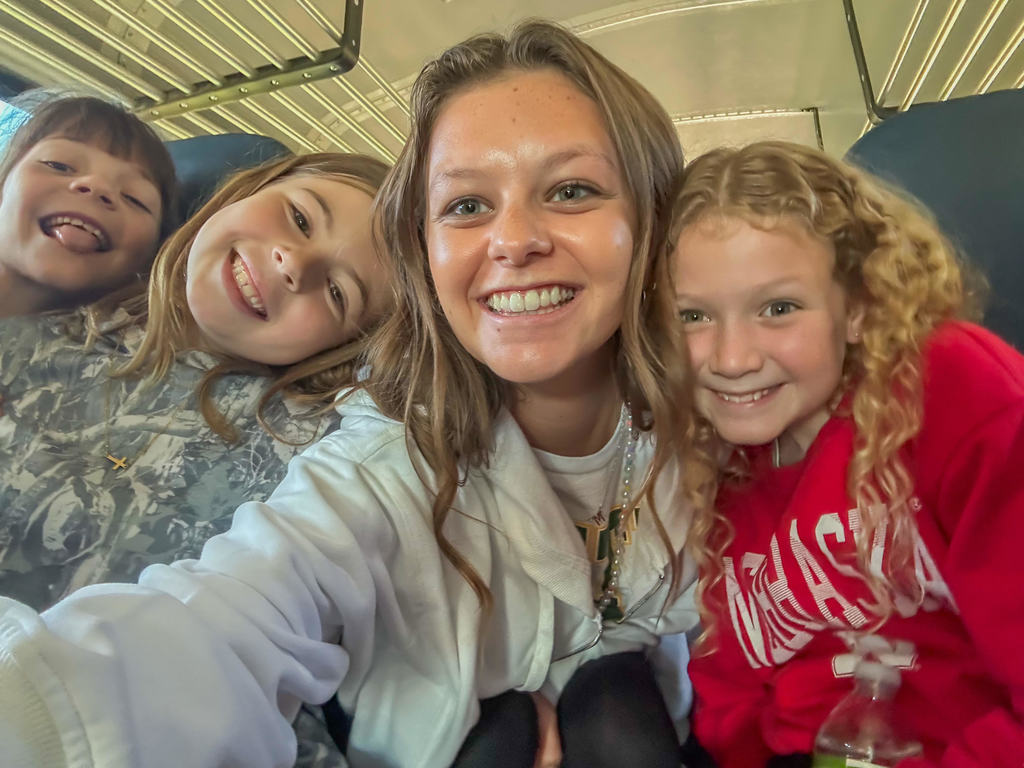teacher and students smiling on the bus