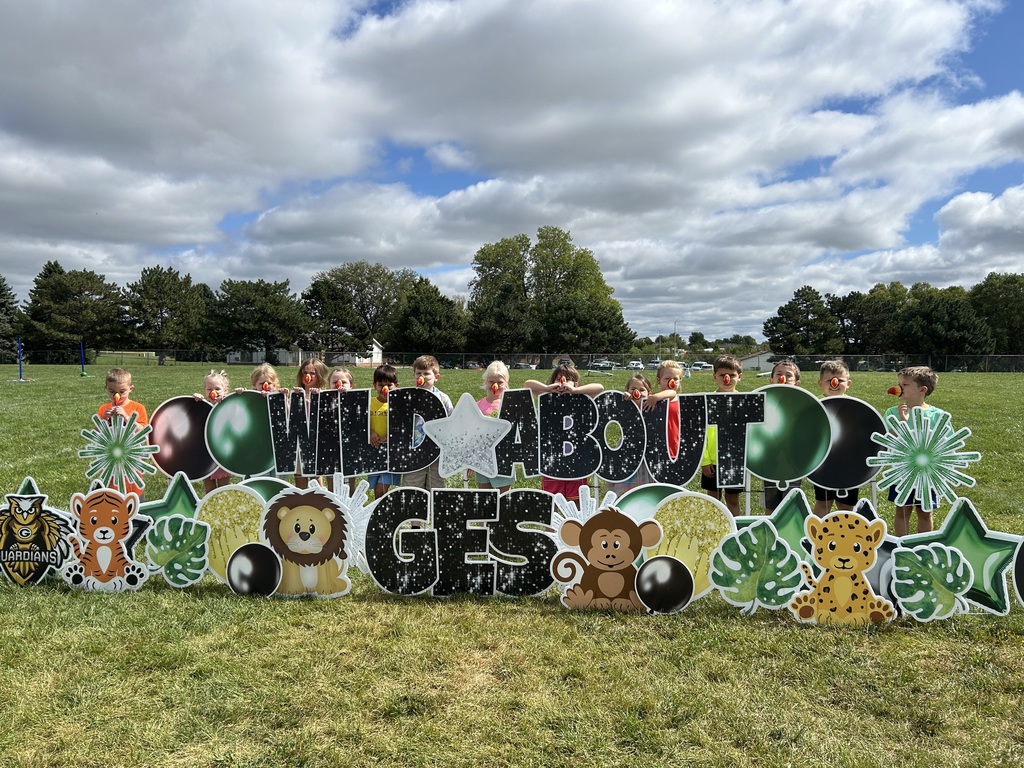 Group of students standing in front of a sign saying Wild About GES.