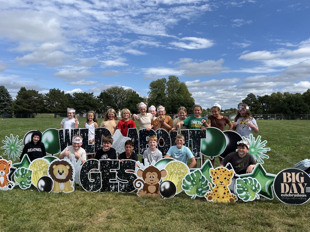 Group of students standing around a sign that says Wild About GES.