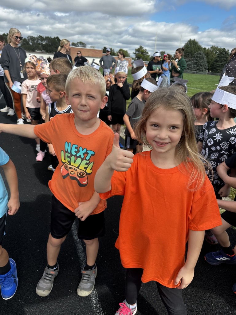 Group of students holding their thumbs up on a running track.