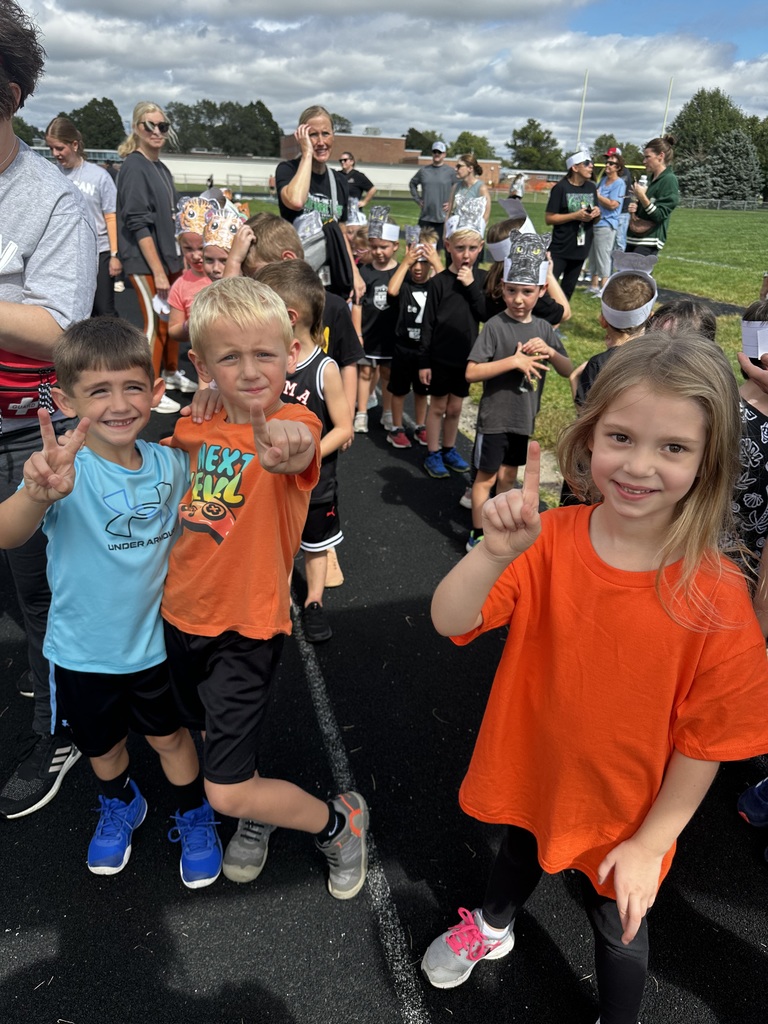 Group of students holding their fingers up on a running track.