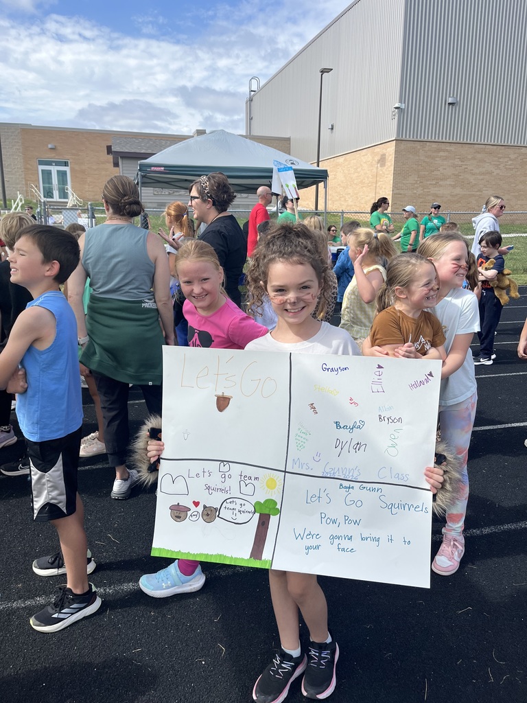 A child holding a poster that says Lets Go Squirrels.