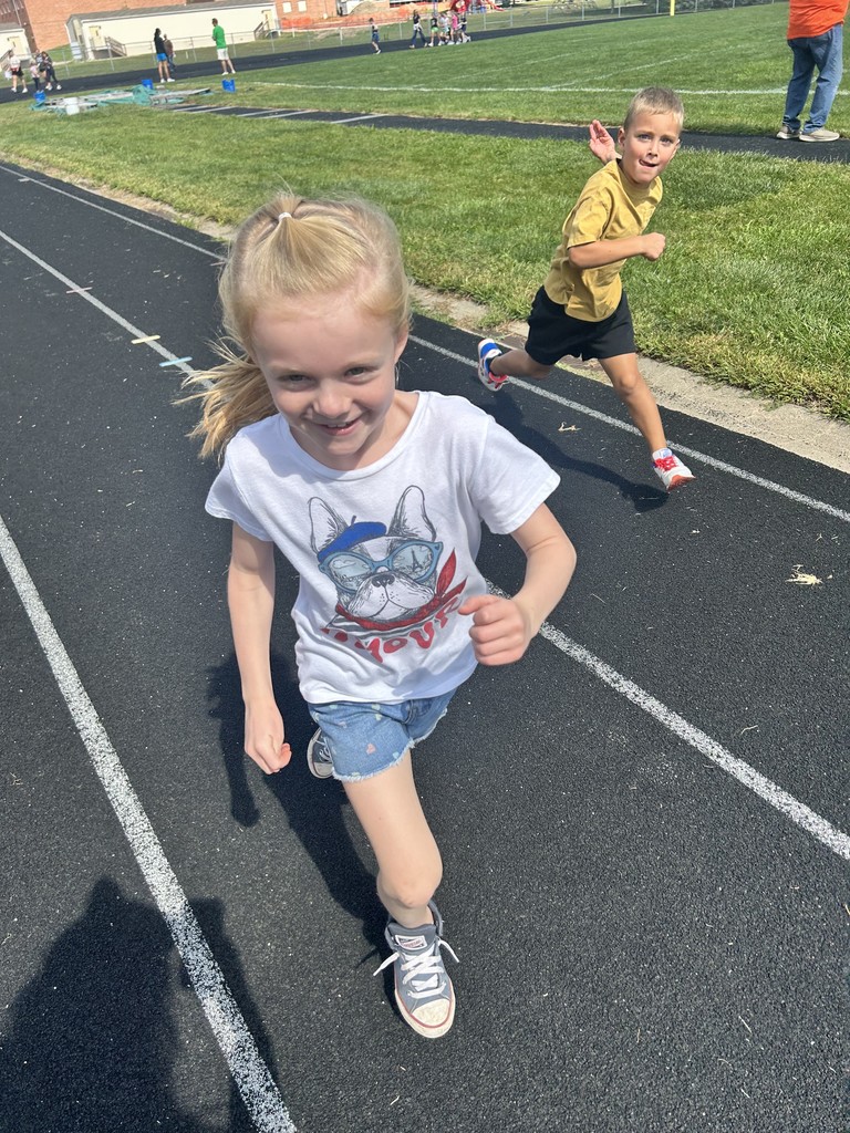 Girl and a boy running on a track.