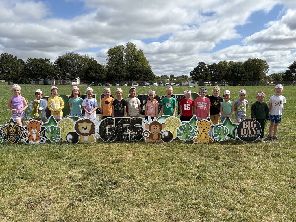 Group of students standing in front of a yard sign showing GES and animals.